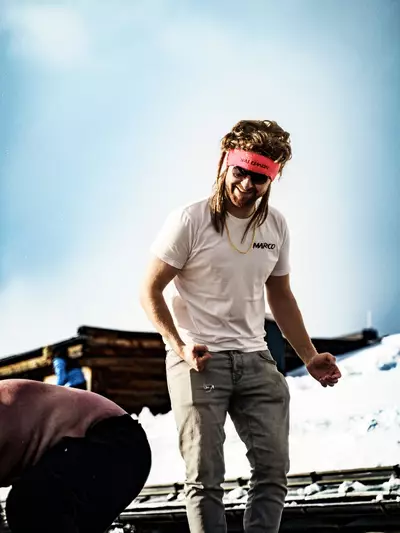 Mann tanzt auf Tisch mit Perücke