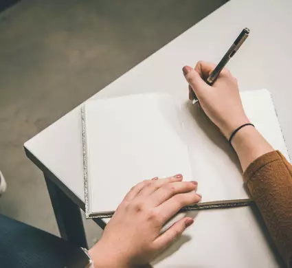 Dame schreibt Infos in ein Buch