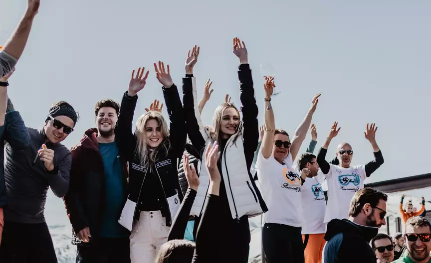 Leute die die Hände in die Luft werfen und tanzen