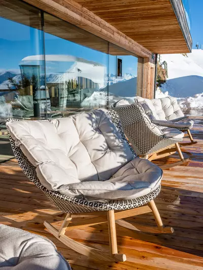 Gemütlicher Schaukelstuhl in der Sonne auf der Terrasse