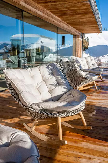 Gemütlicher Schaukelstuhl in der Sonne auf der Terrasse