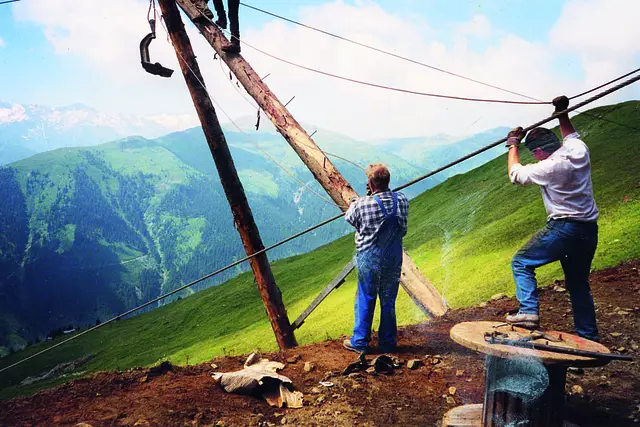 Arbeiter beim Aufstellen einer Seilbahnstütze