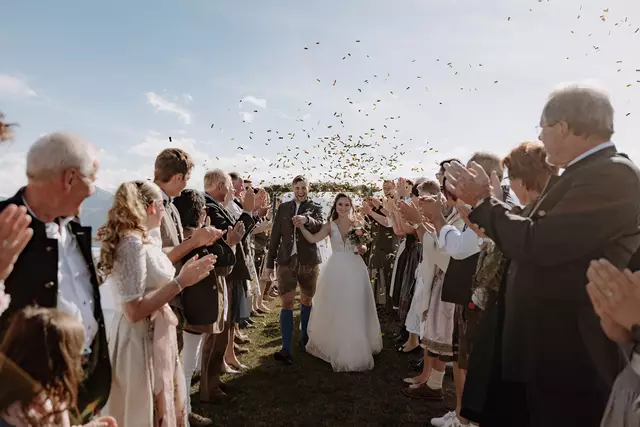 Leute feiern nach Trauung das Brautpaar