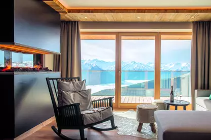 Dekoratives Feuer im Ofen und Schaukelstuhl