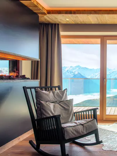 Dekoratives Feuer im Ofen und Schaukelstuhl