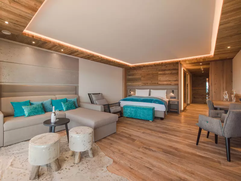 Ansicht Couch mit Tisch, Doppelbett und Schaukelstuhl