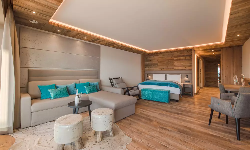 Ansicht Couch mit Tisch, Doppelbett und Schaukelstuhl