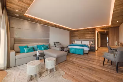 Ansicht Couch mit Tisch, Doppelbett und Schaukelstuhl