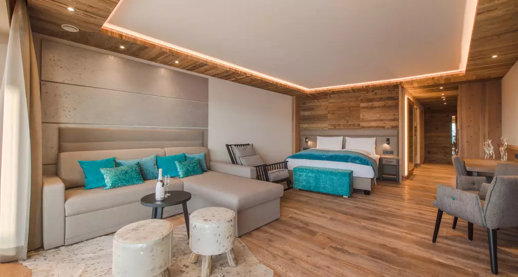 Ansicht Couch mit Tisch, Doppelbett und Schaukelstuhl