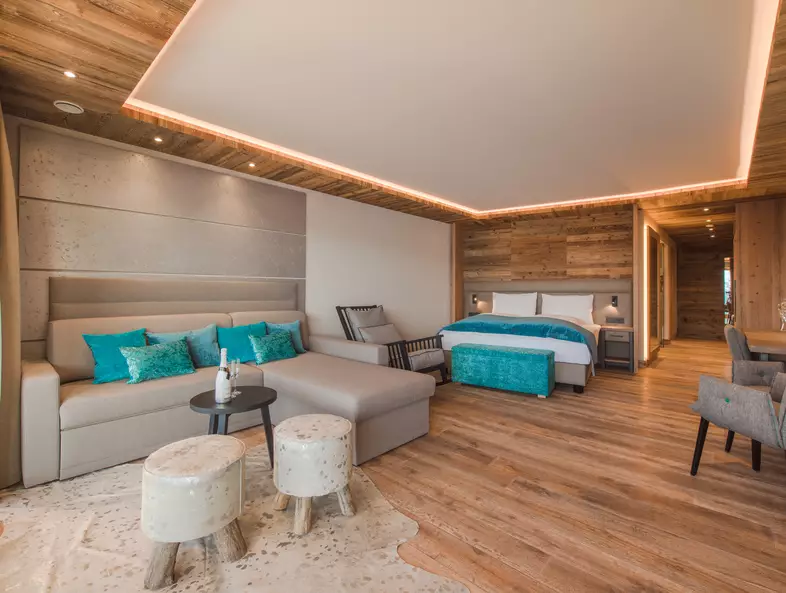 Ansicht Couch mit Tisch, Doppelbett und Schaukelstuhl