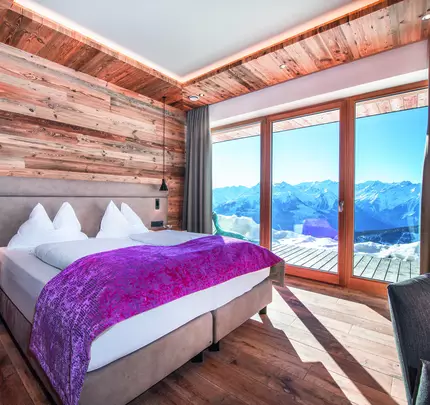 Boxspringbett und Ausblick auf Balkon